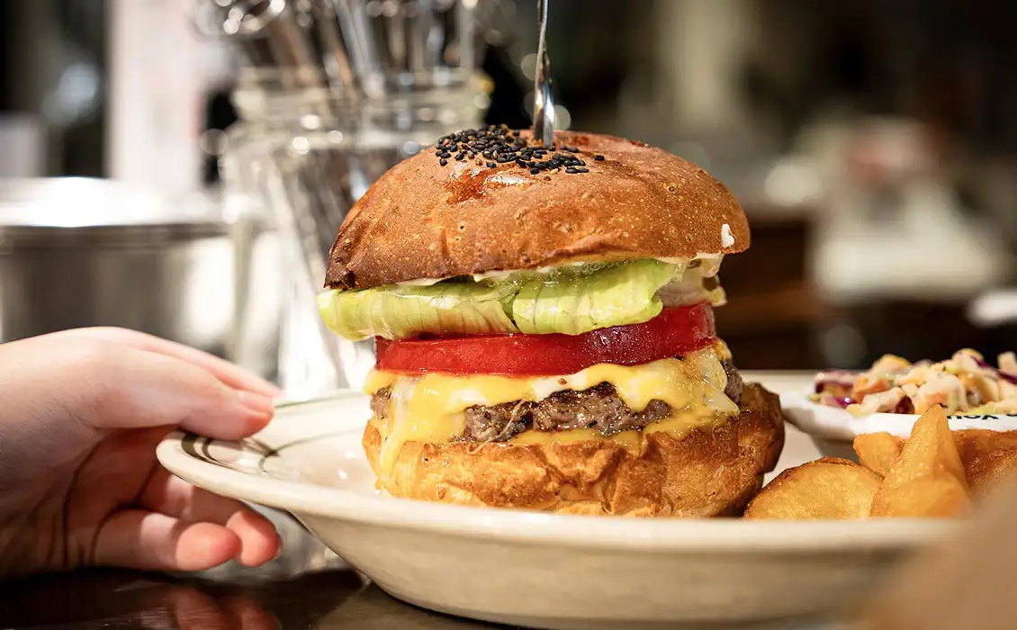 レタスとトマトが入ったチーズバーガーとポテトのプレート