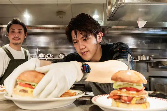 厨房でハンバーガーを盛り付けるスタッフ