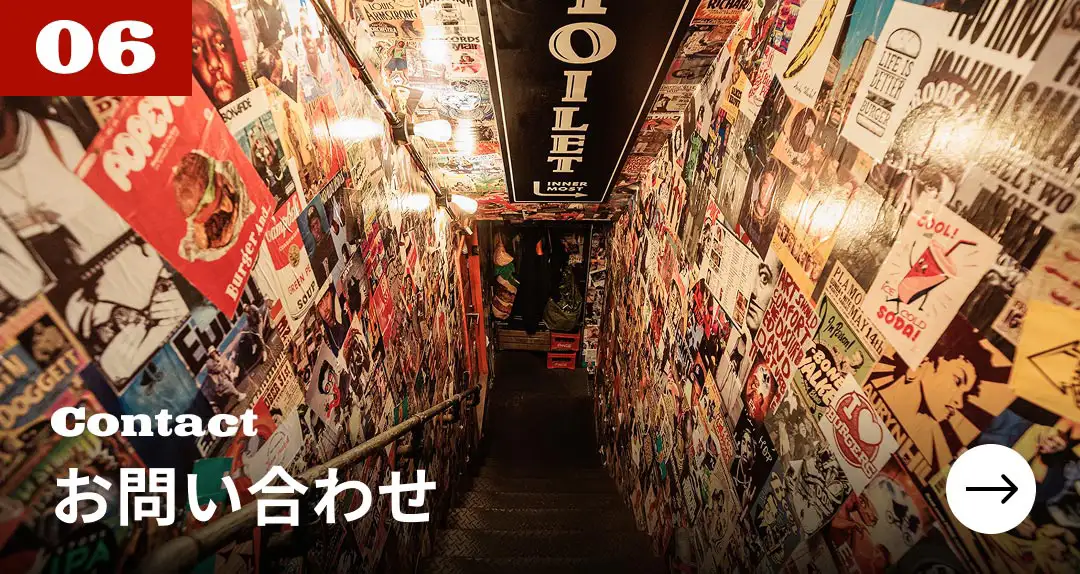 お問い合わせ　ポスターで埋め尽くされた階段の風景