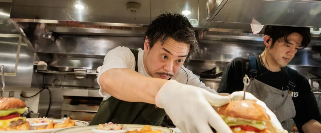代表インタビュー　厨房でハンバーガーを仕上げるスタッフの様子
