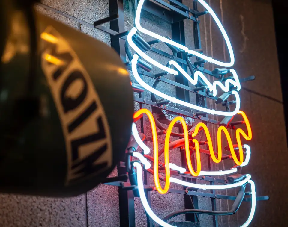 MUNCH'S BURGER SHACK を象徴するバーガーのネオンサイン（代表インタビュー本文イメージ）