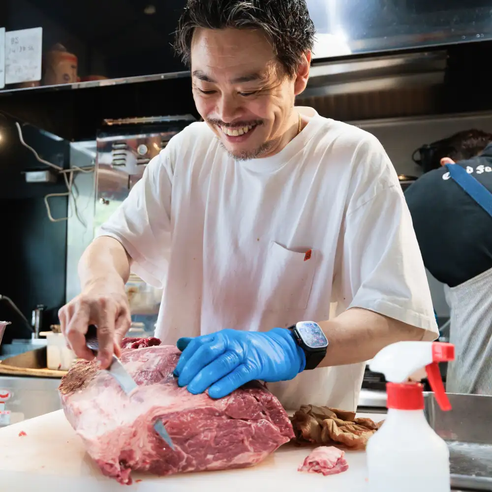 MUNCH'S BURGER SHACK 代表が厨房で肉をカットする姿