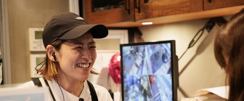 カウンターでお客様と話すスタッフの笑顔