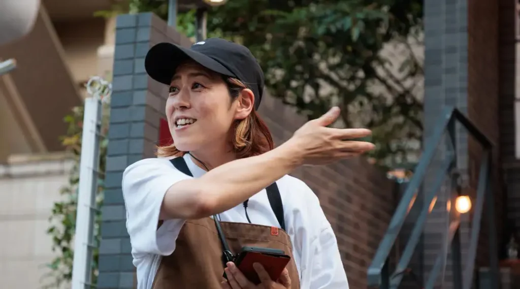 屋外で笑顔で案内するスタッフ