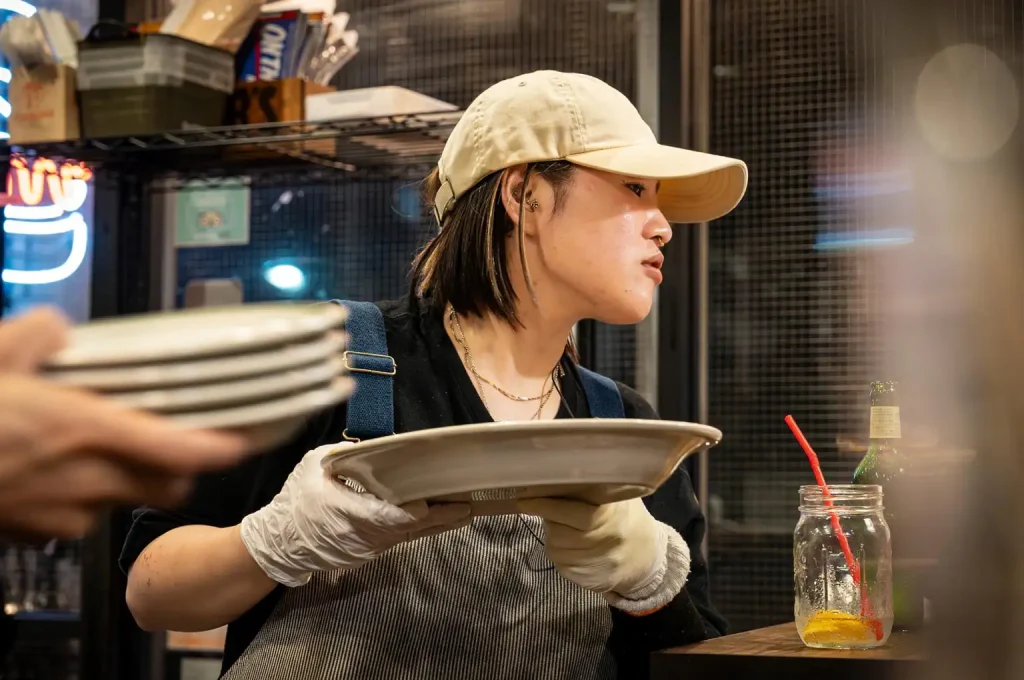 働く仲間（サービススタッフHazukiさん）　お皿を運ぶ姿